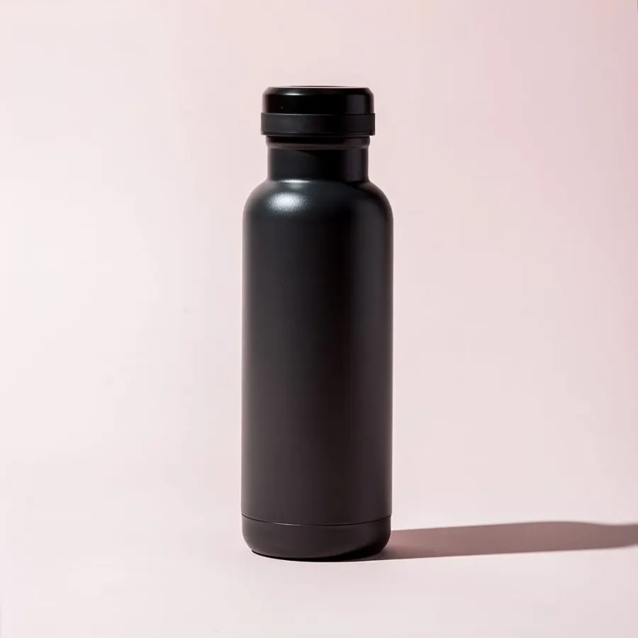 Example result: a matte black water bottle on a pale pink background